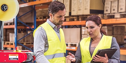 two packaging workers talking to each other